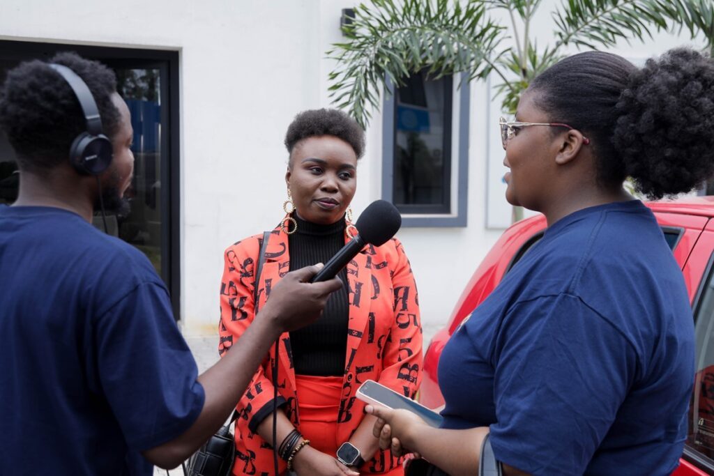 EBO-SURSY Radio_Lady speaking to a group of interviewers